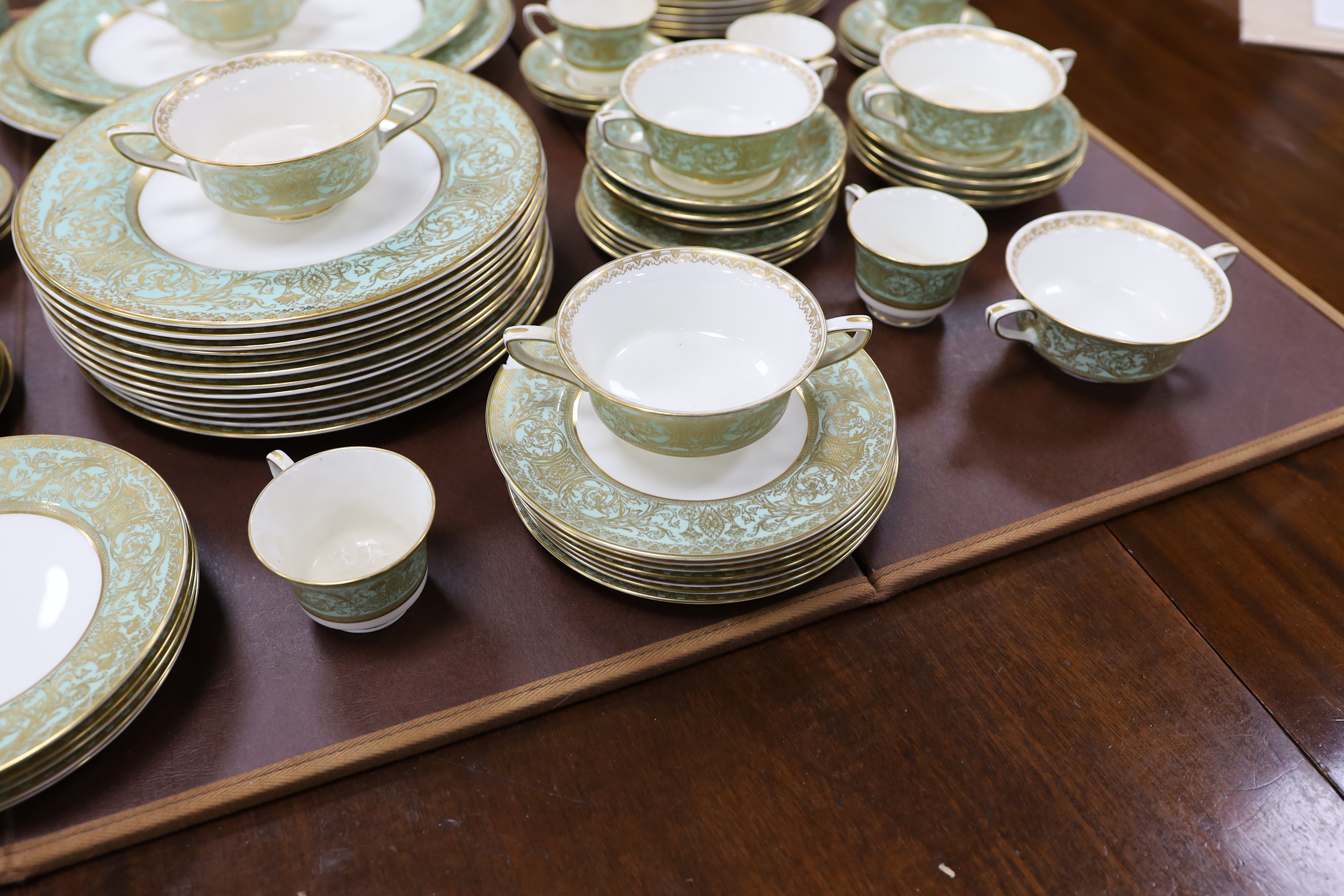 A Royal Worcester green and gilt decorated part dinner service